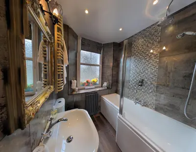 a bathroom with a tub and a sink and a bath tub at Allerdale Guest House in Keswick