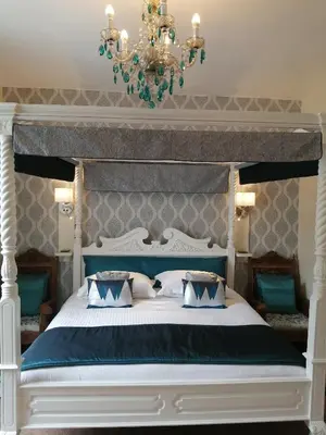 a bedroom with a blue and white bed with a chandelier at Allerdale Guest House in Keswick