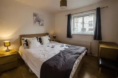 a bedroom with a large bed and a window at The Mariners in Ayr