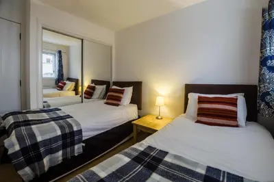 a bedroom with two beds and a mirror at The Mariners in Ayr