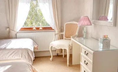 a bedroom with a desk and a chair and a window at Bessiestown Country Guesthouse in Carlisle