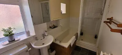 a bathroom with a sink and a toilet and a shower at Criffel Cottage in Dumfries
