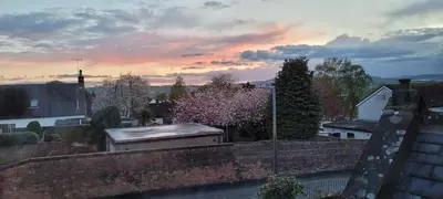 a view from a brick wall with a sunset at Criffel Cottage in Dumfries