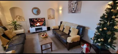 a living room with a christmas tree and a couch at Criffel Cottage in Dumfries