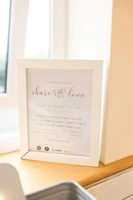 a picture frame on a window sill with a sign that reads silence is lovecal at Galloway View in Castle Douglas