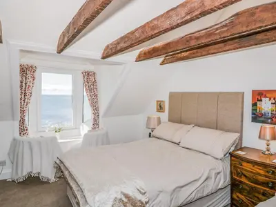 a white bedroom with a bed and a window at Greystones in Newton Stewart