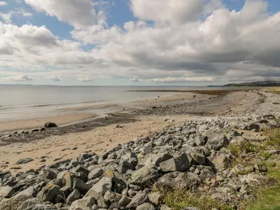 a beach with a large group of rocks at Greystones in Newton Stewart