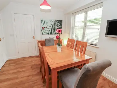 a dining room with a wooden table and chairs at Riverside Cottage in Cockermouth