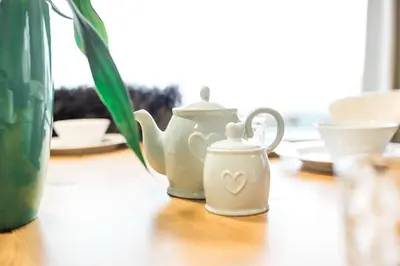 two white tea pots sitting on a wooden table at Fleet View in Gatehouse of Fleet