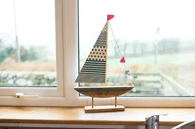 a small wooden boat sitting on a window sill at Fleet View in Gatehouse of Fleet