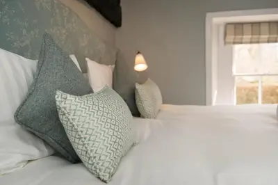 a bedroom with a white bed with pillows and a window at The Horse and Farrier Inn and The Salutation Inn Threlkeld Keswick in Threlkeld
