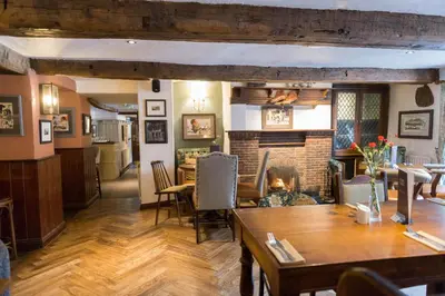 a living room with a table and a fireplace at The Horse and Farrier Inn and The Salutation Inn Threlkeld Keswick in Threlkeld