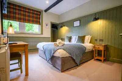 a bedroom with a bed and a desk in it at The Horse and Farrier Inn and The Salutation Inn Threlkeld Keswick in Threlkeld
