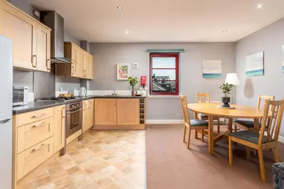 a kitchen with a table and a dining room at Elliot Suite No15 - Donnini Apartments in Ayr