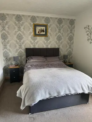 a bedroom with a large bed and two night stands at Prince Charlie's Cottage in Gretna Green