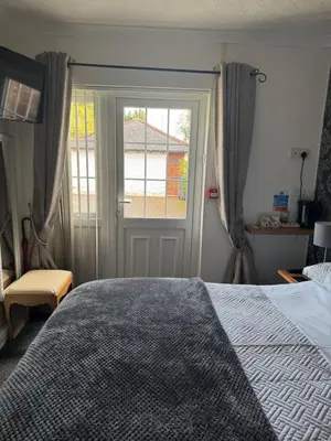 a bedroom with a large bed and a window at Prince Charlie's Cottage in Gretna Green