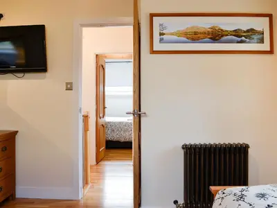 a hallway with a door leading to a bedroom at Ghillie Cottage in Cockermouth