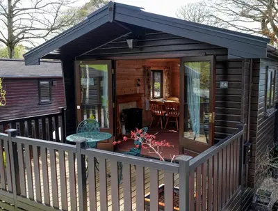 a wooden cabin with a deck with a patio at Fellside Lodge in Keswick