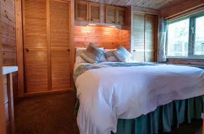 a bedroom with a white bed in a wooden room at Fellside Lodge in Keswick