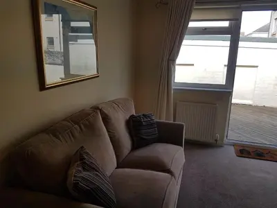 a living room with a couch and a window at Fairways Cottages in Prestwick