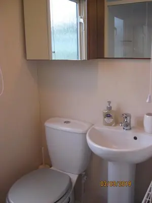 a bathroom with a white toilet and a sink at 27 The Beeches, Gilcrux, Nr Cockermouth, Cumbria in Gilcrux