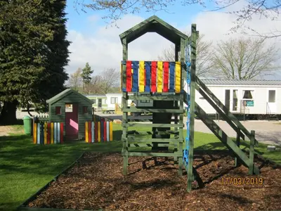 a playground with a colorful slide in a park at 27 The Beeches, Gilcrux, Nr Cockermouth, Cumbria in Gilcrux