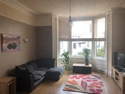 a living room with a couch and a large window at Ravensworth House in Keswick