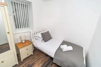 a small bedroom with a bed and a window at Sam's Cottage in Keswick