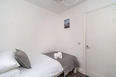 a bedroom with a bed with two white towels on it at Sam's Cottage in Keswick
