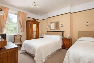 a bedroom with two beds and a window at Acorn House in Keswick