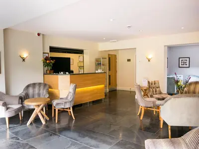a waiting room with chairs and a reception desk at Glaramara Hotel in Borrowdale Valley