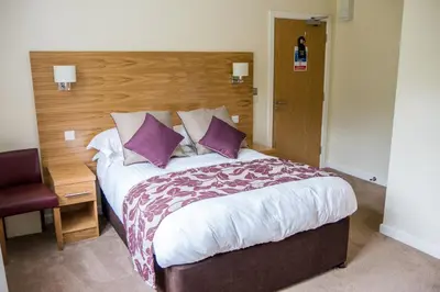 a bedroom with a large bed with purple pillows at Glaramara Hotel in Borrowdale Valley