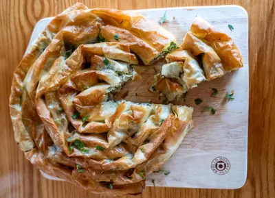 a pie on a cutting board on a table at Welbeck Hotel & Apartments IOM in Douglas
