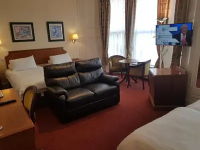 a hotel room with a couch and a chair at Welbeck Hotel & Apartments IOM in Douglas