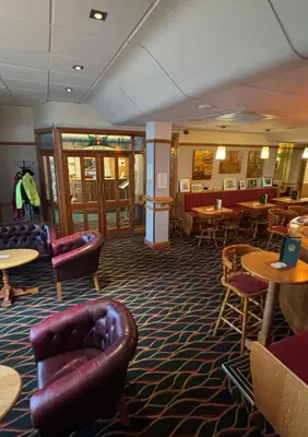 a restaurant with couches and tables and chairs at Welbeck Hotel & Apartments IOM in Douglas