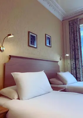 two beds in a hotel room with white pillows at Welbeck Hotel & Apartments IOM in Douglas