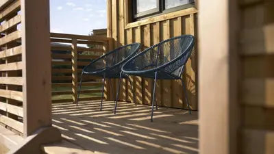 two blue chairs sitting on a deck at Glen Wyllin Campsite in Kirkmichael