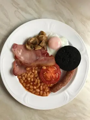 a white plate of food with beans and bacon at Winchester House in Keswick