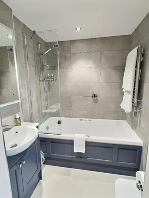 a bathroom with a tub and a sink and a shower at Three Shires Inn in Little Langdale