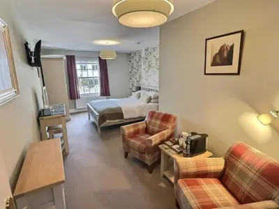 a hotel room with a bed and a living room at Three Shires Inn in Little Langdale