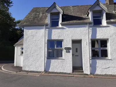 a white house with a door on a street at Stanger Cottage in Keswick