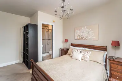a bedroom with a large bed and a chandelier at Lords Seat in Keswick