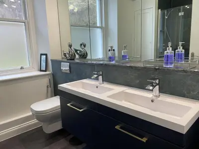 a bathroom with a sink and a toilet and a mirror at Lords Seat in Keswick