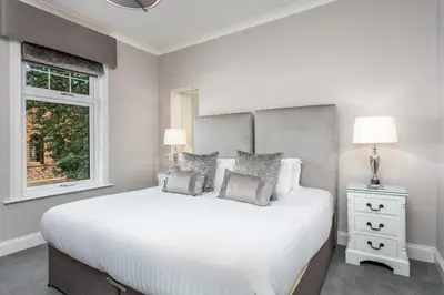 a bedroom with a large white bed and a window at The Alexander - Donnini Deluxe in Prestwick