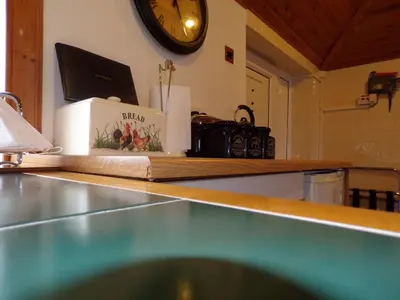 a kitchen counter with a clock on the wall at Groom's Cottage in Moffat
