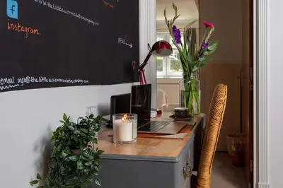 a desk with a laptop computer and a candle on it at Turnberry Serviced Apartments in Turnberry
