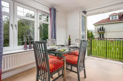 a dining room with a table and chairs on a balcony at Turnberry Serviced Apartments in Turnberry