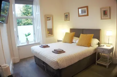 a bedroom with a bed with two towels on it at Barns Serviced Accommodation in Ayr