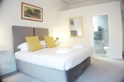 a bedroom with a large white bed with yellow pillows at Barns Serviced Accommodation in Ayr