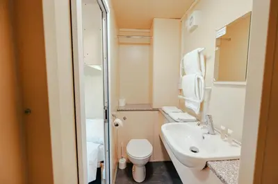 a small bathroom with a toilet and a sink at IOMTT Village at Isle of Man TT in Douglas